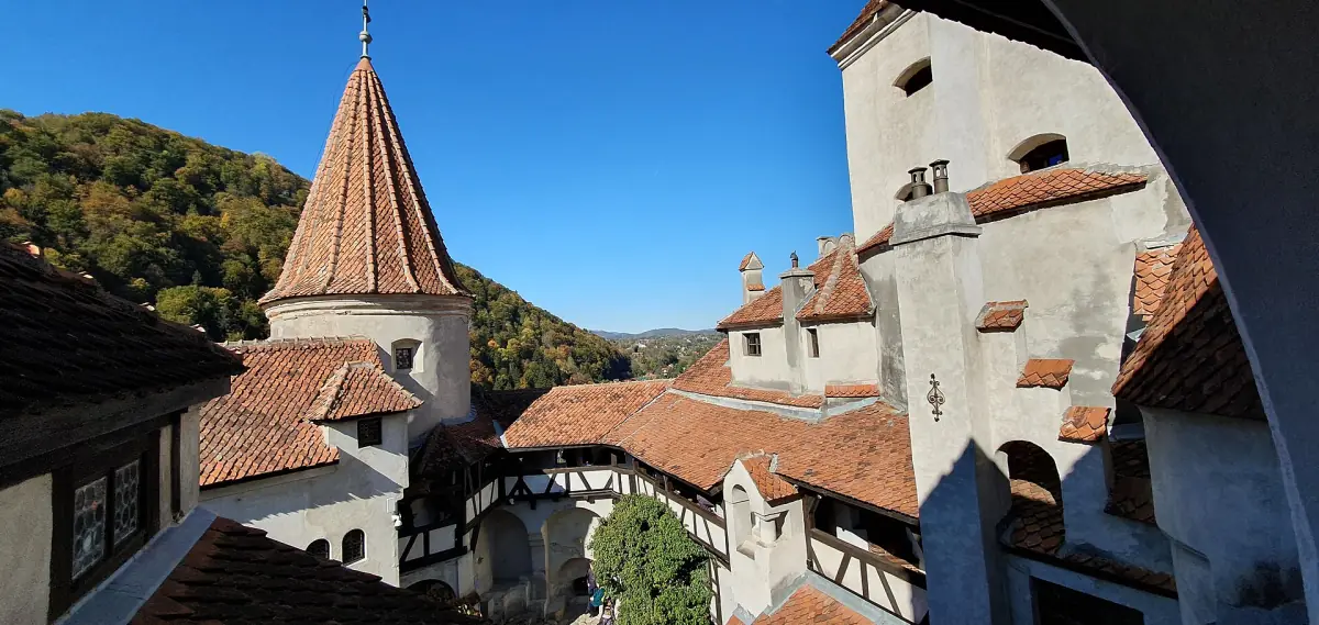 Red tiled roofs and a round tower around the castle courtyard in sunshine