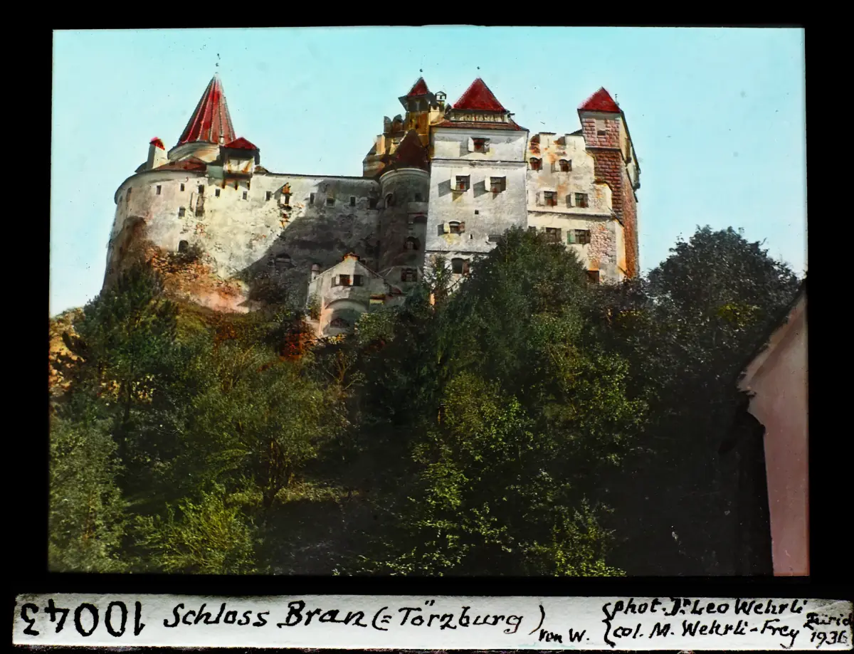 Historic colour slide of Bran Castle on a forested hill from the west