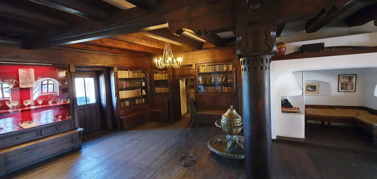 Wood panelled room with bookshelves and a central wooden pillar