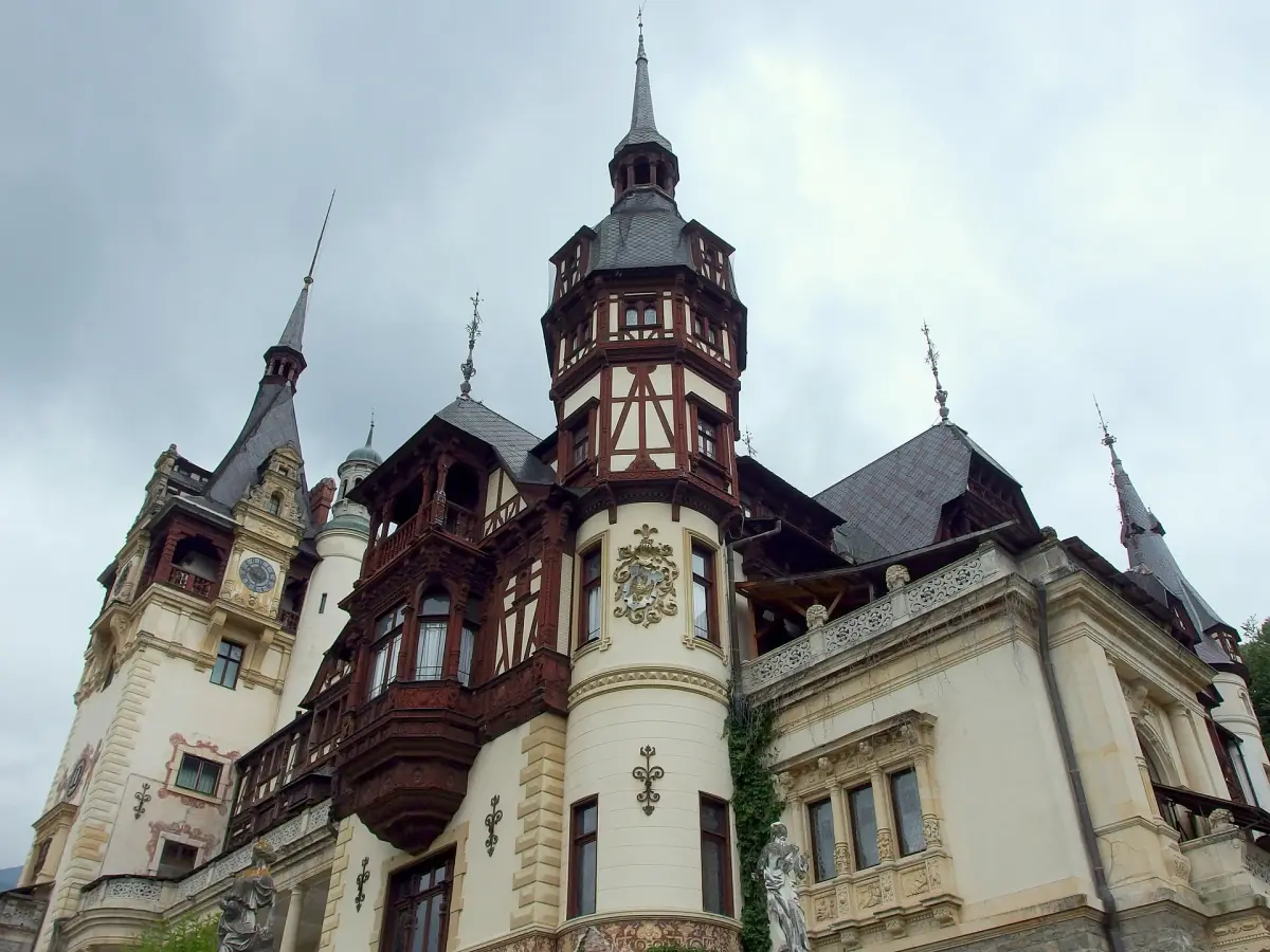 Close view of the timbered facade and tower of Peleș Castle