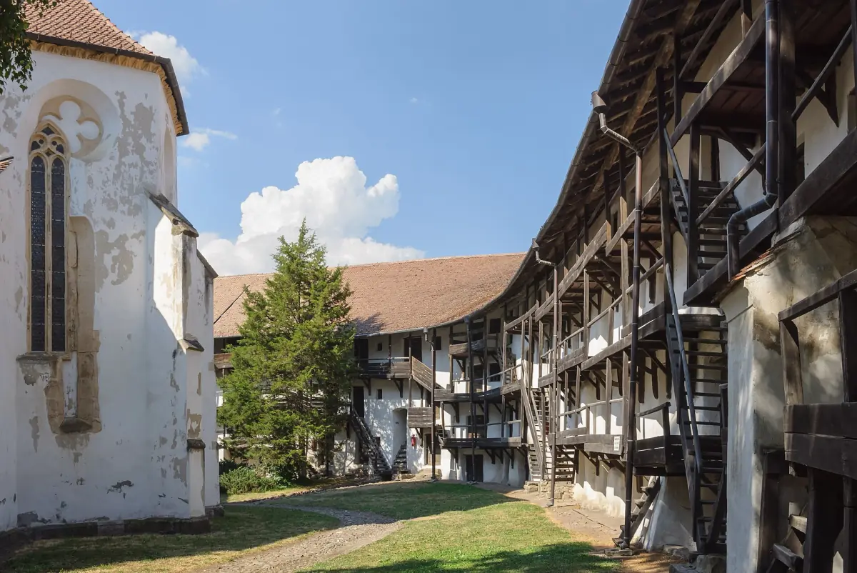 Inner courtyard of a fortified church with tiered wooden galleries along the wall